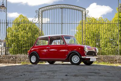 a small red car that is parked in front of a gate