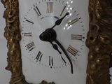 a gold frame with a clock in it on a table