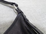 a close up of a black purse on a white surface