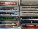 six modèles réduits de trains différents, dans leurs boîtes, posés sur une table