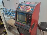une borne d'arcade rouge et noire dans un coin de la pièce
