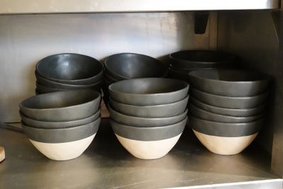 de nombreux bols et casseroles sur l'étagère de la cuisine
