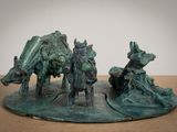 une sculpture en bronze représentant un homme à cheval et une vache