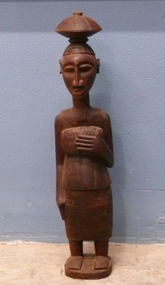 statue en bois représentant une femme coiffée d'un chapeau