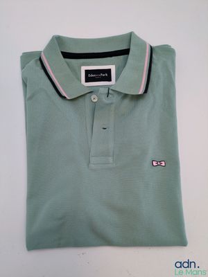 un polo vert avec une rayure rose au niveau du col