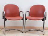 two red chairs sitting next to each other on the floor