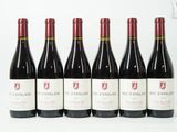 six bouteilles de vin rouge alignées sur une surface blanche