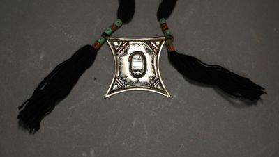 a close up of a necklace with a picture of a person on it