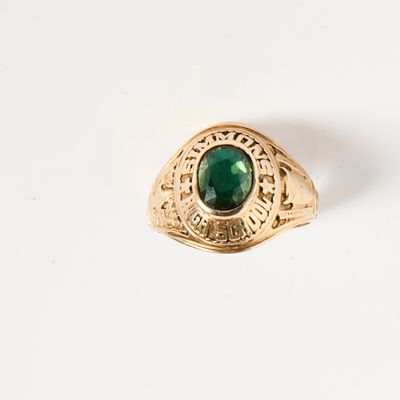 une image d'une bague en or avec une pierre verte au centre