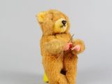un ours en peluche qui tient une aiguille entre ses pattes