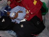 a pile of clothes that is sitting on a bed