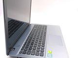 a silver laptop with a black keyboard on a white surface