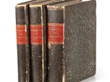 three old books sitting on top of each other on a white surface