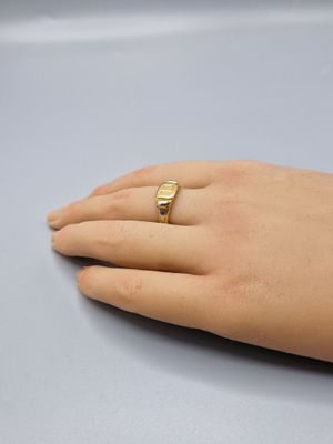 a woman ' s hand with a gold ring on it