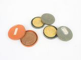 quatre petites boîtes contenant des pièces de monnaie, posées sur une surface blanche