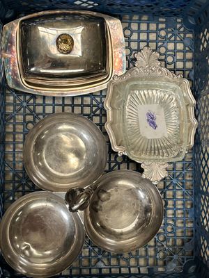 beaucoup de plats en argent dans un panier posé sur la table
