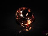 a close up of a large brown diamond on a black surface