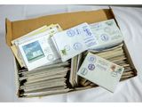une boîte remplie de timbres et d'enveloppes posée sur un lit