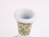 a white vase with a green and yellow design on it