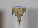 a white vase with a gold decoration on it