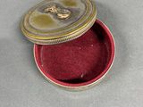 a small red box with a silver lid on a table
