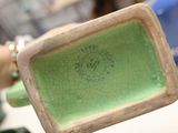 someone is holding a small green plate with a design on it