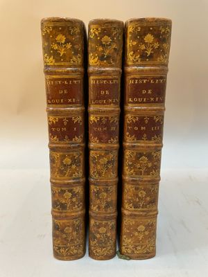 un ensemble de quatre livres anciens en cuir avec des couvertures dorées et rouges