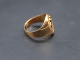 a close up of a gold signet ring on a table