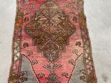 an old rug with a pink and brown design on it