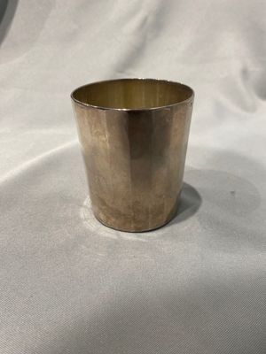 une image représentant une coupe en or posée sur un tissu blanc
