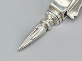 a silver pen with a pointed tip sitting on a table