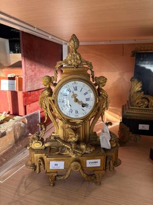une horloge en or posée sur une table dans une pièce