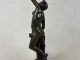 bronze statue of a man holding a bird in his hand