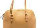 Le grand sac à main beige est posé sur une surface blanche.