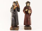 pair of wooden figurines of two people holding cups of coffee