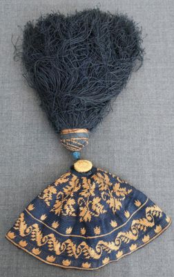 un gros plan d'un chapeau bleu et or orné d'une plume