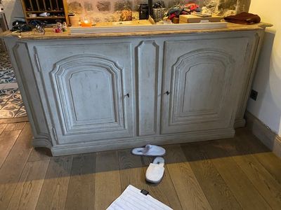une chaussure posée par terre à côté d'une armoire