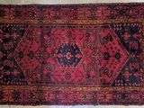 a red and black rug with a design on it