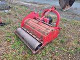 une machine rouge qui est garée dans l'herbe