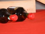 two bottles of wine sitting on a red cloth