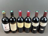 six bottles of wine are lined up in a row on a table