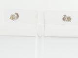 deux paires de boucles d'oreilles posées sur une surface blanche