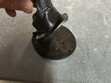 a hand that is holding a metal object on a table
