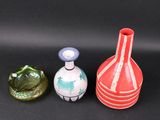three vases sitting next to each other on a black surface