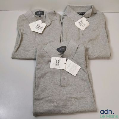 three men ' s polo shirts with tags on them sitting on a table