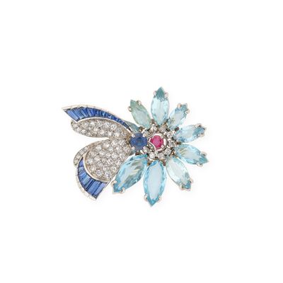 un gros plan sur une broche en forme de fleur ornée de pierres bleues et blanches
