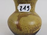 a yellow vase with a number on it on a white surface