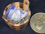a small wooden basket with a coin next to it