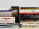 many books stacked on top of each other on a table