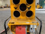 a close up of a yellow machine in a large warehouse